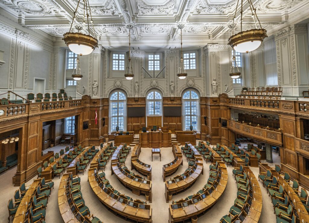 Folketingssalen på Christiansborg med de tomme pladser i halvcirkel og formandsstolen for enden.