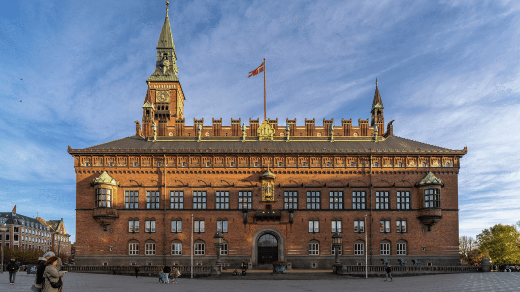 Stor rødstensbygning med kobberspir i København.